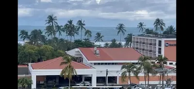 a building with palm trees in front of the ocean at 2BR with ocean view in Jacó