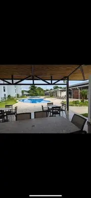 a group of tables and chairs in a pavilion with a pool at 2BR with ocean view in Jacó