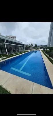 a large swimming pool in front of a building at 2BR with ocean view in Jacó