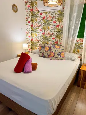 a bed with colorful pillows on it in a room at Casa Guarumo in Manuel Antonio
