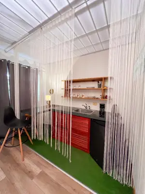 a kitchen with white curtains and a desk with a chair at Casa Guarumo in Manuel Antonio