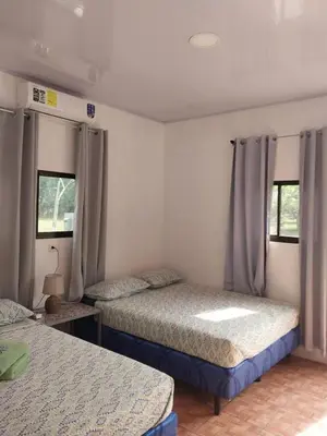 a bedroom with two beds and two windows at Apartamento de playa del Caribe in Moín