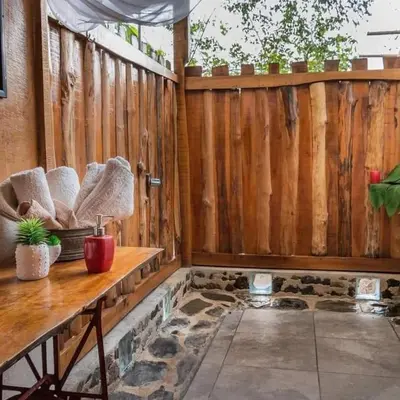 a patio with a wooden fence and a wooden table at Helenors estancia in Nicoya