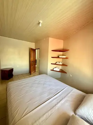 a bedroom with a large white bed and shelves at Apartamento Bella Vista in Quepos