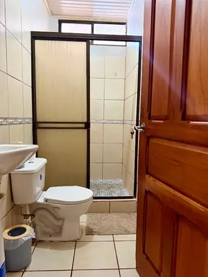 a bathroom with a toilet and a sink and a shower at Apartamento Bella Vista in Quepos