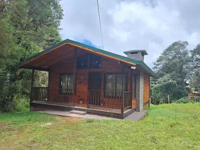 a small wooden cabin in a grassy field at Cabaña de montaña in Cañón