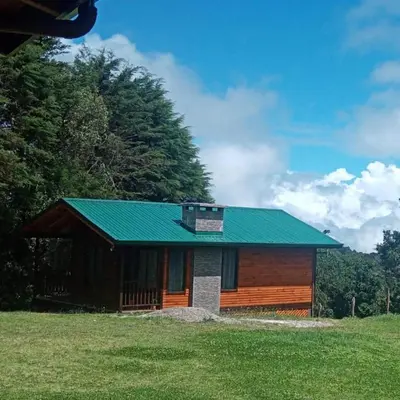 a small building with a green roof on a field at Cabaña de montaña in Cañón