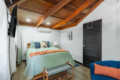 a bedroom with a bed and a tv in it at Villa Sunrise - Incredible Ocean Views! in Ocotal