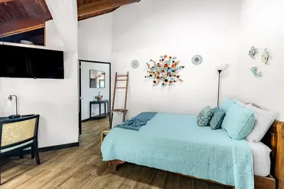a bedroom with a bed and a flat screen tv at Villa Sunrise - Incredible Ocean Views! in Ocotal