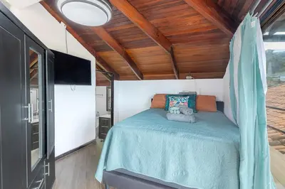 a bedroom with a bed and a tv in a room at Villa Sunrise - Incredible Ocean Views! in Ocotal