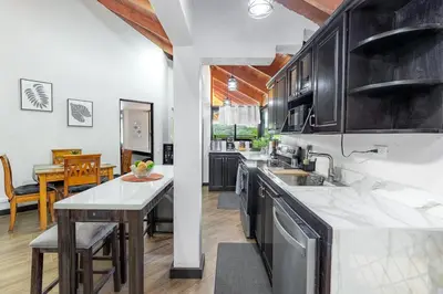 a kitchen with black cabinets and a counter top at Villa Sunrise - Incredible Ocean Views! in Ocotal