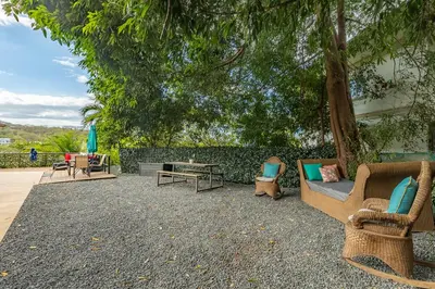 a patio with chairs and a table and a tree at Villa Sunrise - Incredible Ocean Views! in Ocotal