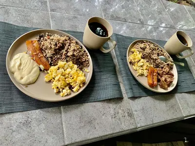two plates of breakfast food on a table with coffee at Luna Escondida in Sarapiquí