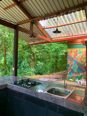 an outdoor kitchen with a sink and a roof at Luna Escondida in Sarapiquí