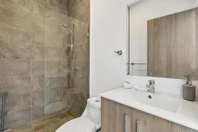 a bathroom with a toilet and a sink and a shower at 8-min Walk to Beach with Pool & Golf in Pochote