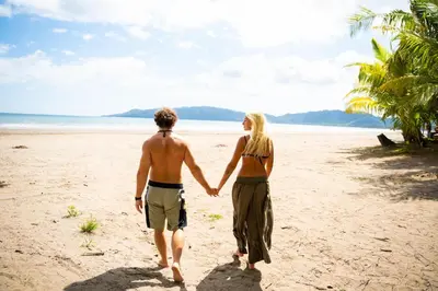 a man and a woman walking on the beach at 8-min Walk to Beach with Pool & Golf in Pochote