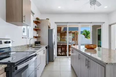 a kitchen with white cabinets and a counter top at Casa Anbara Private Pool in Pochote