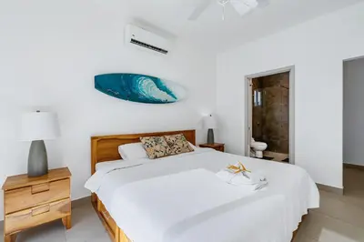 a bedroom with a large bed and a nightstand with a blue fish above it at Casa Anbara Private Pool in Pochote