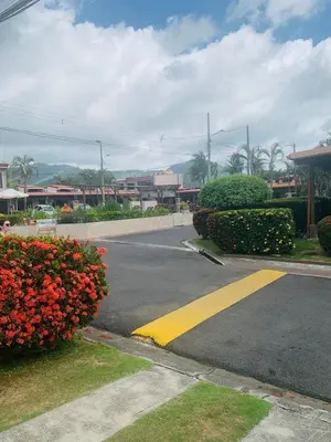 an empty street with flowers on the side of the road at Cosy condo in Jaco Park, 450m from the beach 6pax in Jacó