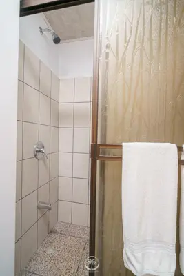 a shower with a glass door and a towel at Cosy condo in Jaco Park, 450m from the beach 6pax in Jacó