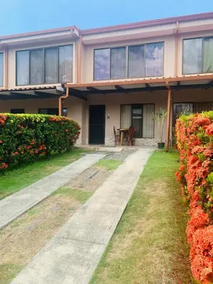 a house with a pathway in front of it with flowers at Cosy condo in Jaco Park, 450m from the beach 6pax in Jacó