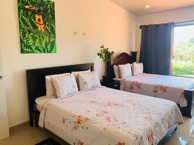 a bedroom with two beds and a window at Cosy condo in Jaco Park, 450m from the beach 6pax in Jacó