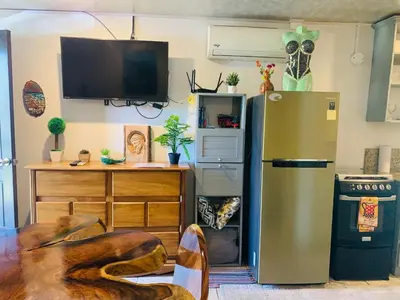a kitchen with a stainless steel refrigerator and a table at Cosy condo in Jaco Park, 450m from the beach 6pax in Jacó