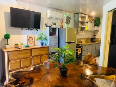 a living room with a table and a refrigerator at Cosy condo in Jaco Park, 450m from the beach 6pax in Jacó