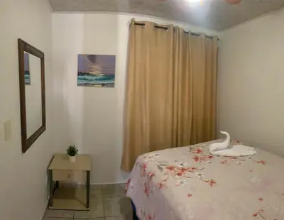 a bedroom with a bed with a swan on it at Cosy condo in Jaco Park, 450m from the beach 6pax in Jacó