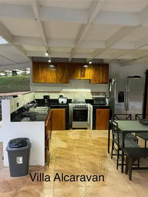 a kitchen with wooden cabinets and a table with chairs at villa Alcaravan - 4 rooms home in Lagunillas
