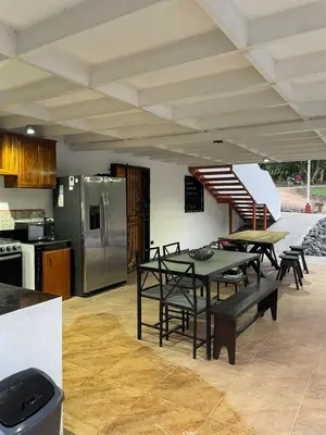 a kitchen with a table and a stainless steel refrigerator at villa Alcaravan - 4 rooms home in Lagunillas