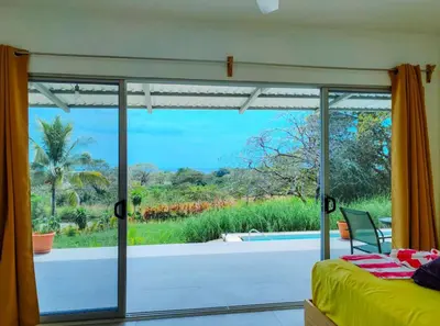 a bedroom with a view of a patio from a window at Casa Assaya in Nandayure