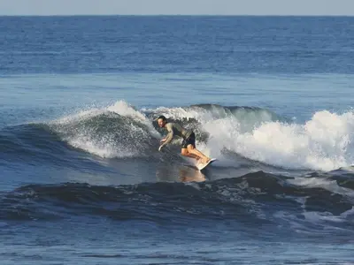 a man riding a wave on a surfboard in the ocean at Casa Assaya in Nandayure