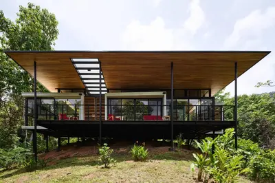 a house on a hill with a large roof at Sinfonía Tropical, ocean view, 5 minutes driving to Playa Linda, 15 to Dominical, wifi Starlink in Savegre