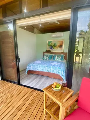 a bedroom in a tiny house with a bed and a table at Sinfonía Tropical, ocean view, 5 minutes driving to Playa Linda, 15 to Dominical, wifi Starlink in Savegre