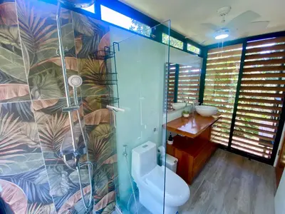 a bathroom with a shower and a toilet and a sink at Sinfonía Tropical, ocean view, 5 minutes driving to Playa Linda, 15 to Dominical, wifi Starlink in Savegre