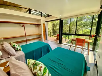 a room with a bed and a couch and a window at Sinfonía Tropical, ocean view, 5 minutes driving to Playa Linda, 15 to Dominical, wifi Starlink in Savegre