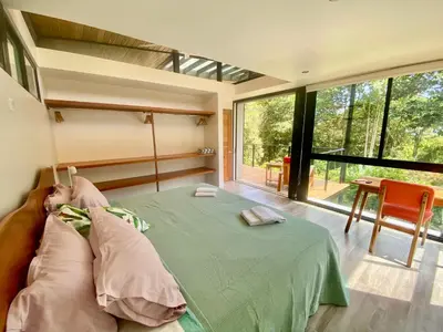a bedroom with a bed and a large window at Sinfonía Tropical, ocean view, 5 minutes driving to Playa Linda, 15 to Dominical, wifi Starlink in Savegre