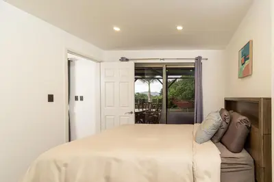 a bedroom with a bed and a door to a porch at Private 3-Bedroom, 35-Bathroom Home With Amazing Ocean-Views In Playa Grande in Playa Grande