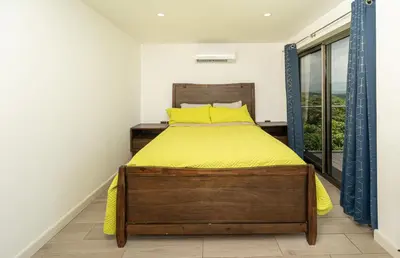 a bedroom with a bed with yellow sheets and a window at Private 3-Bedroom, 35-Bathroom Home With Amazing Ocean-Views In Playa Grande in Playa Grande