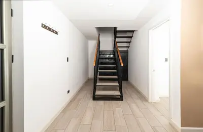 a staircase in a room with white walls and wooden floors at Private 3-Bedroom, 35-Bathroom Home With Amazing Ocean-Views In Playa Grande in Playa Grande
