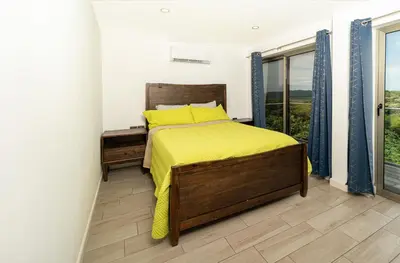 a bedroom with a bed with yellow sheets and a window at Private 3-Bedroom, 35-Bathroom Home With Amazing Ocean-Views In Playa Grande in Playa Grande