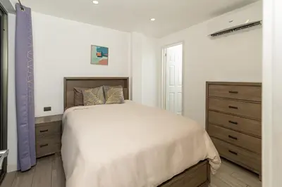 a white bedroom with a large bed and a dresser at Private 3-Bedroom, 35-Bathroom Home With Amazing Ocean-Views In Playa Grande in Playa Grande
