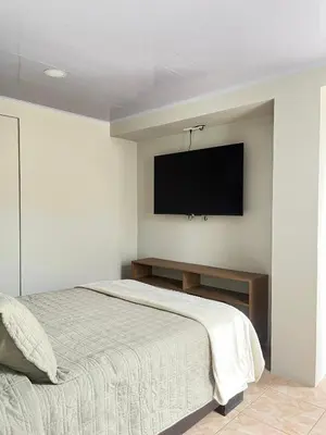 a bedroom with a bed and a television on the wall at Bajamar, Puntarenas in Puntarenas