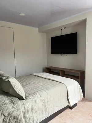 a bedroom with a bed and a flat screen tv at Bajamar, Puntarenas in Puntarenas