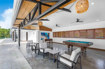 a room with a pool table and chairs at Upstay - New Condo Just Steps Away from the Beach in Jacó