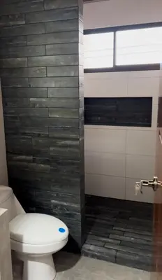 a bathroom with a toilet and a tile wall at Cachorro, Puntarenas in Puntarenas