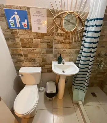 a bathroom with a toilet and a sink at The Backside House - Women Only - in Tamarindo