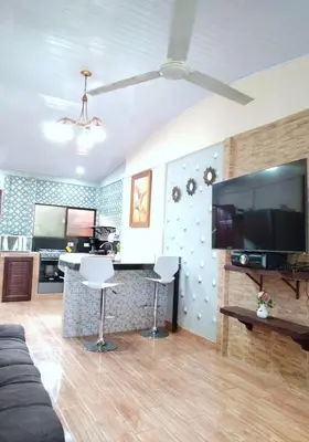 a living room with a flat screen tv and a couch at Casa vacacional Brisa Del Mar in Coco