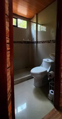 a bathroom with a toilet and a tub and a window at Casa vacacional Brisa Del Mar in Coco